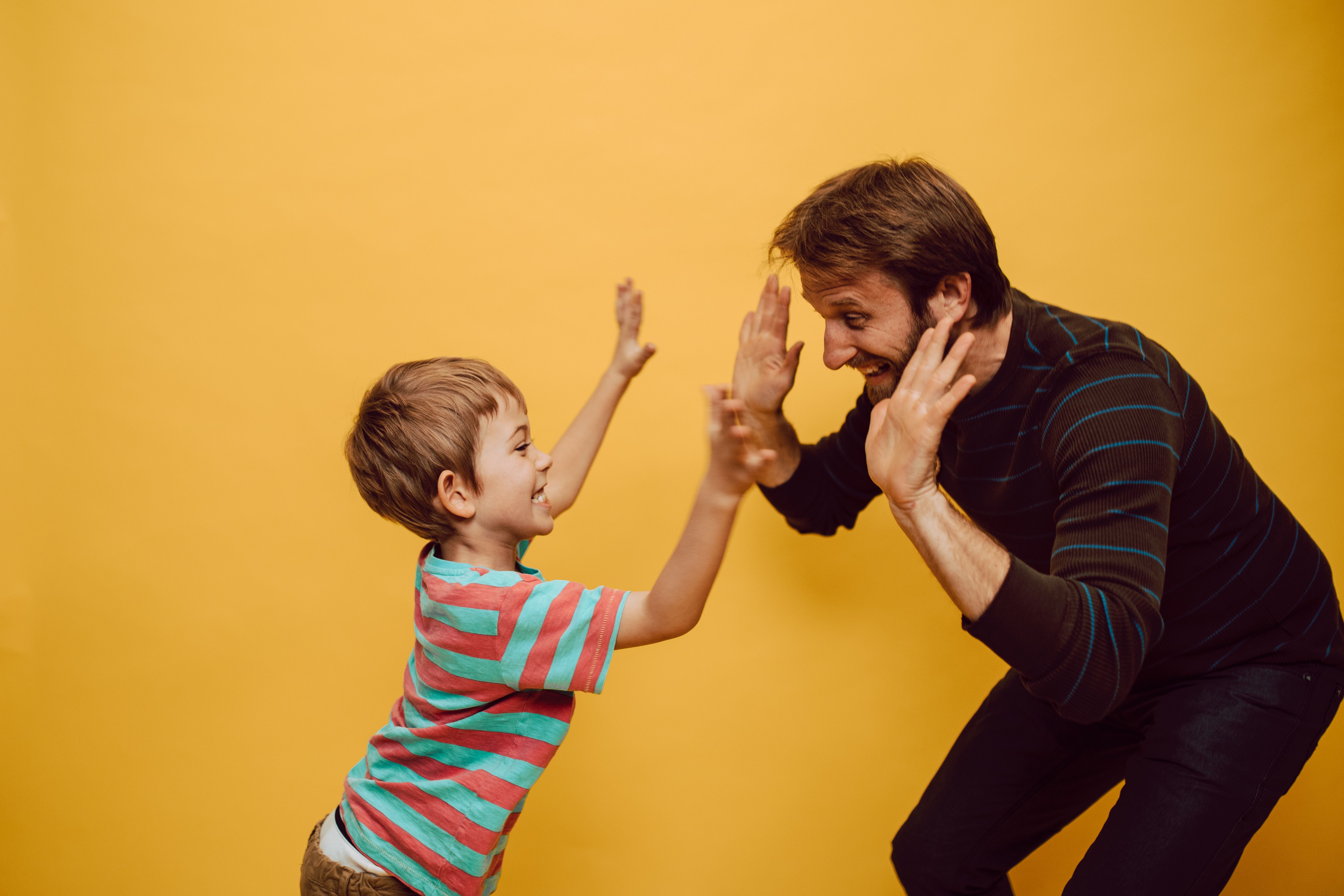 Two people high fiving each other